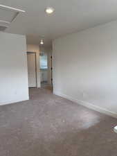 Carpeted empty room featuring a textured ceiling