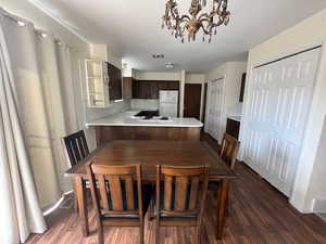 Dining area with dark hardwood / wood-style floors and an inviting chandelier