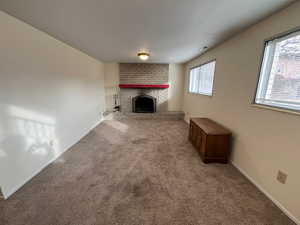 Unfurnished living room featuring a fireplace and carpet