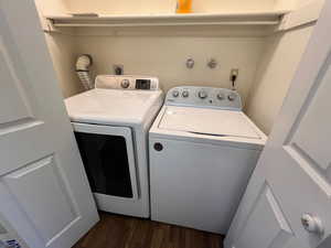 Laundry room with separate washer and dryer and dark hardwood / wood-style floors