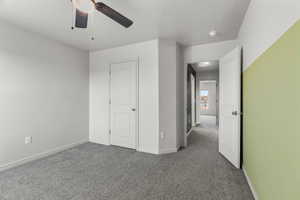 Unfurnished bedroom featuring a textured ceiling, carpet floors, and ceiling fan