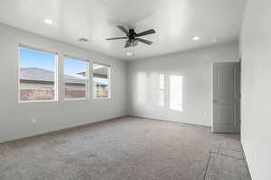 Carpeted empty room with a textured ceiling and ceiling fan