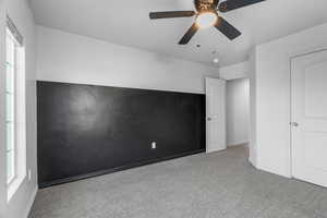 Unfurnished bedroom featuring light carpet, multiple windows, and ceiling fan