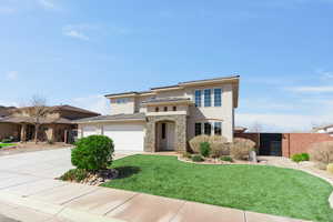 Prairie-style house featuring stucco siding, fence, a garage, stone siding, and driveway