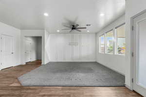 Empty room featuring hardwood / wood-style floors, a textured ceiling, and ceiling fan