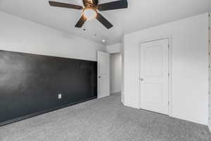 Unfurnished bedroom with light colored carpet and ceiling fan