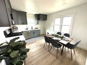 Kitchen with sink, gray cabinets, stainless steel appliances, and light hardwood / wood-style floors