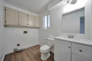 Bathroom featuring vanity, hardwood / wood-style floors, a textured ceiling, and toilet