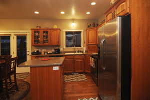 Kitchen featuring sink, stainless steel fridge, dark hardwood / wood-style flooring, a kitchen island, and electric stove