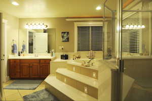 Bathroom featuring tile patterned flooring, vanity, and independent shower and bath