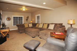 Carpeted living room with beamed ceiling