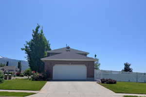 View of front of property featuring a mountain view, a garage, and a front yard