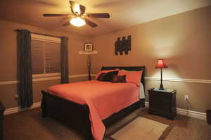 Carpeted bedroom featuring ceiling fan