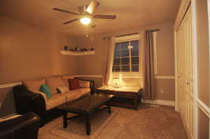 Living room featuring carpet floors and ceiling fan