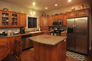 Kitchen with stainless steel appliances, dark hardwood / wood-style floors, a center island, and sink