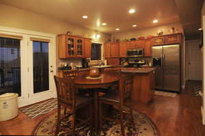 Kitchen with a kitchen bar, sink, dark hardwood / wood-style floors, a kitchen island, and stainless steel appliances