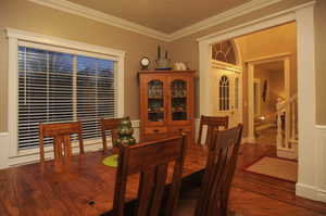 Dining area with crown molding and wood-type flooring