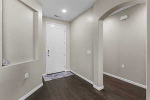 Doorway with dark hardwood / wood-style flooring