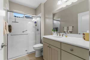 Guest Bathroom featuring vanity, toilet, and a shower with shower door