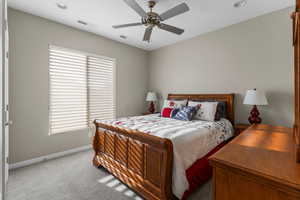 2nd Bedroom with ceiling fan and light carpet