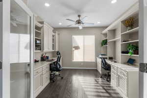 Office area featuring ceiling fan, dark hardwood / wood-style flooring, and built in desk