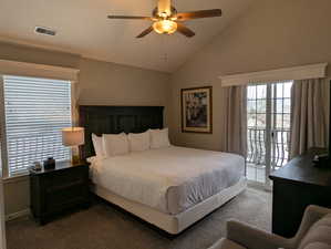 Carpeted bedroom with ceiling fan, lofted ceiling, and access to exterior