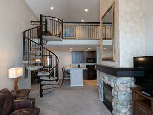 Carpeted living room with a high ceiling and a fireplace