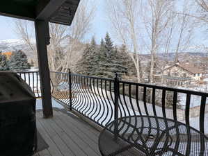 Snow covered deck with area for grilling and a mountain view