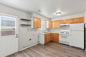 Kitchen featuring sink, white appliances, and light hardwood / wood-style floors