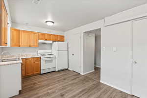 Kitchen with white appliances, sink, and hardwood / wood-style floors