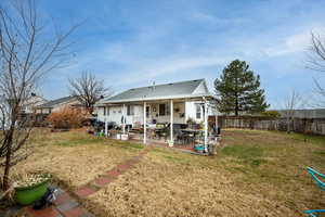 Rear view of property featuring a yard and a patio area