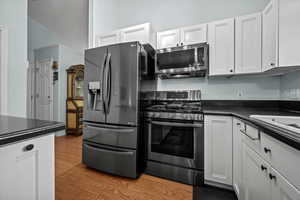 Kitchen featuring white cabinetry, appliances with stainless steel finishes, and light hardwood / wood-style floors