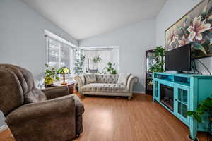 Living room with lofted ceiling and hardwood / wood-style flooring