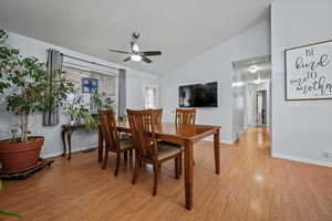 Dining area with lofted ceiling, ceiling fan, and light hardwood / wood-style flooring