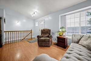 Living room with lofted ceiling and light hardwood / wood-style floors