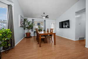 Dining room featuring ceiling fan, lofted ceiling, and light hardwood / wood-style floors