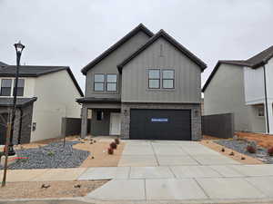 View of front facade with an attached garage, board and batten siding, and concrete driveway