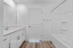 Bathroom featuring vanity, hardwood / wood-style floors, and  shower combination