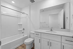 Full bathroom featuring toilet, hardwood / wood-style floors, vanity, and  shower combination