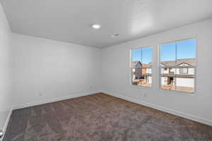 Unfurnished room with carpet and a textured ceiling