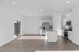 Kitchen featuring sink, white cabinetry, a center island with sink, light wood-type flooring, and appliances with stainless steel finishes