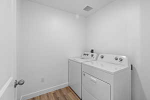 Laundry room featuring separate washer and dryer and hardwood / wood-style floors