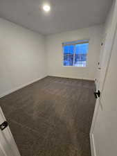 Unfurnished room with carpet floors and a textured ceiling