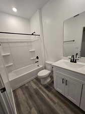 Full bathroom with washtub / shower combination, toilet, a textured ceiling, vanity, and hardwood / wood-style floors