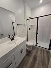 Bathroom with vanity, hardwood / wood-style flooring, toilet, and walk in shower