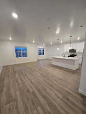 Unfurnished living room with hardwood / wood-style flooring, sink, and a textured ceiling