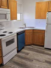 Kitchen with white appliances, dark hardwood / wood-style flooring, and sink