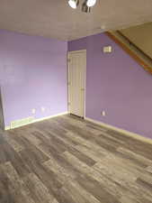 Additional living space featuring hardwood / wood-style floors and a textured ceiling