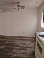 Kitchen with ceiling fan, a textured ceiling, dark hardwood / wood-style flooring, and electric stove