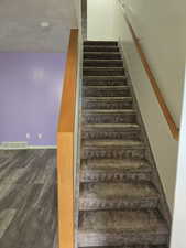 Stairs featuring hardwood / wood-style flooring and a textured ceiling